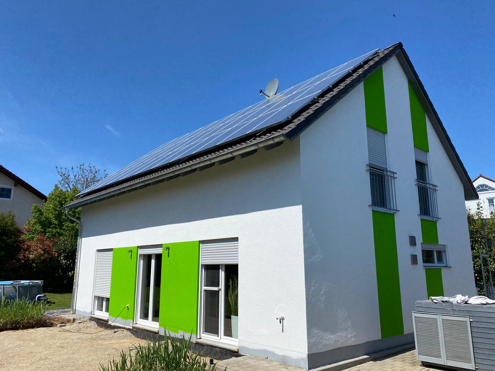Ein Haus mit Solarpanelen auf dem Dach, das umweltfreundliche Energie erzeugt.